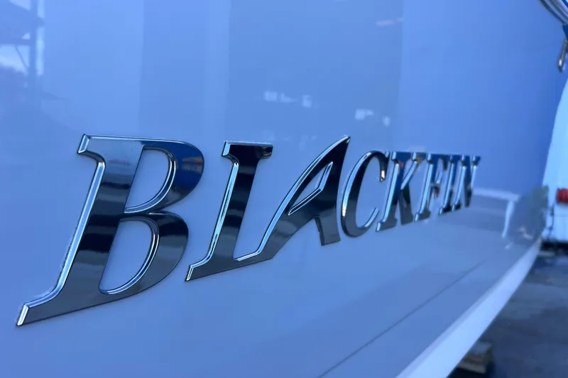 Slide: The Image of Close-up of 2022 Blackfin 272 DC boat logo on hull. - 27
