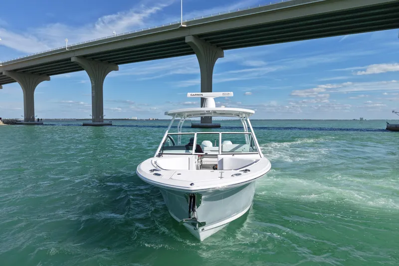 Slide: The Image of 2022 Blackfin 272 DC boat cruising under a bridge on clear blue water. - 3
