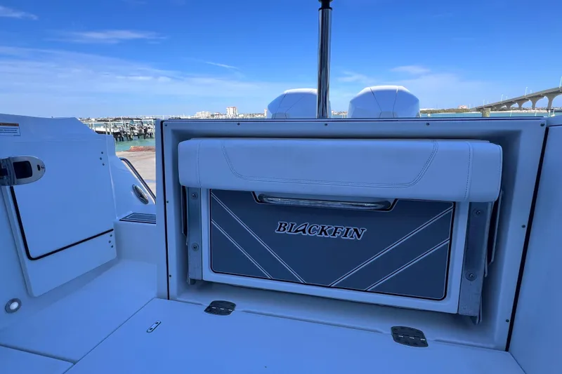 Slide: The Image of 2022 Blackfin 272 DC boat interior with seating and storage, dockside view. - 35