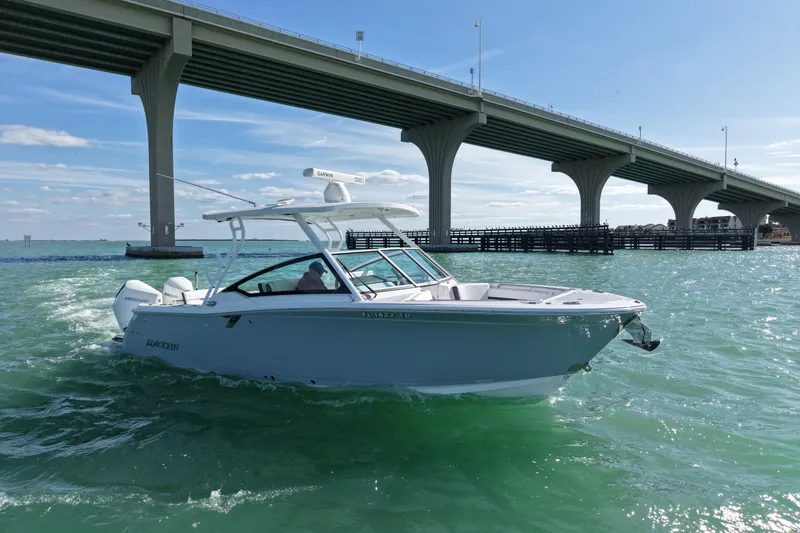 Slide: The Image of 2022 Blackfin 272 DC boat cruising under a bridge on a sunny day. - 4
