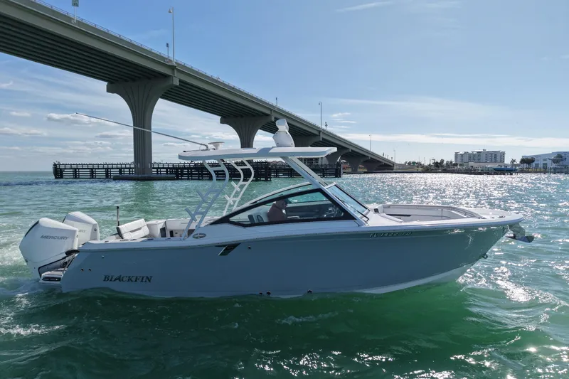 Slide: The Image of 2022 Blackfin 272 DC boat cruising under a bridge on a sunny day. - 5