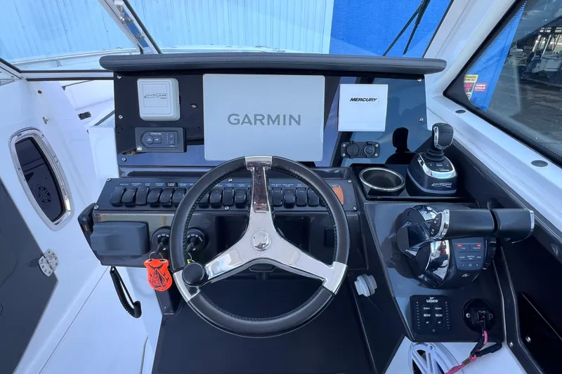Slide: The Image of 2022 Blackfin 272 DC helm with Garmin and Mercury controls, sleek design. - 58