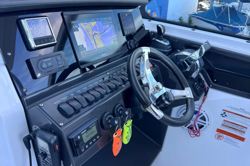 Slide: The Image of 2022 Blackfin 272 DC boat dashboard with steering wheel and navigation controls. - 62