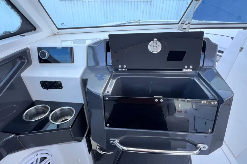 Slide: The Image of 2022 Blackfin 272 DC boat interior with cup holders and storage compartment. - 77