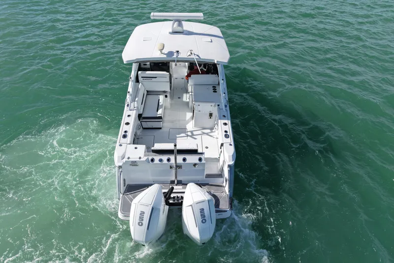 Slide: The Image of 2022 Blackfin 272 DC boat cruising on open water, rear view. - 8