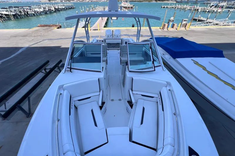 Slide: The Image of 2022 Blackfin 272 DC boat docked, showcasing spacious seating and sleek design. - 85