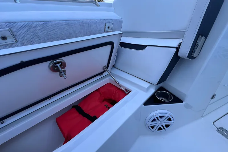 Slide: The Image of 2022 Blackfin 272 DC boat interior with storage compartment and red life jacket. - 87