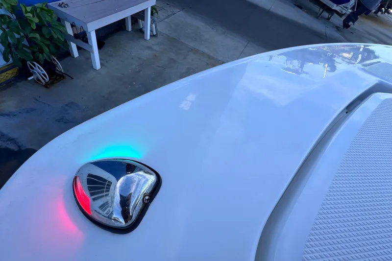 Slide: The Image of 2022 Blackfin 272 DC boat with navigation lights, docked near a table and plant. - 90