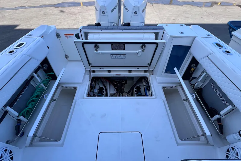 Slide: The Image of 2022 Blackfin 272 DC boat interior with open storage compartments and visible engine area. - 92