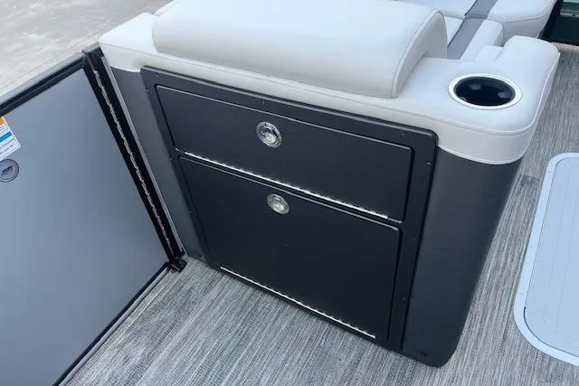 Slide: The Image of 2026 Godfrey Monaco 235 SFLC boat interior with storage compartments and cup holder. - 13