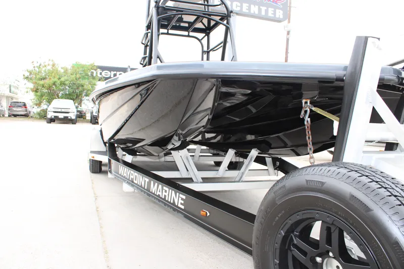 Slide: The Image of 2025 Mamba 24 Catamaran Elite deck with open storage compartment and trolling motor. - 23