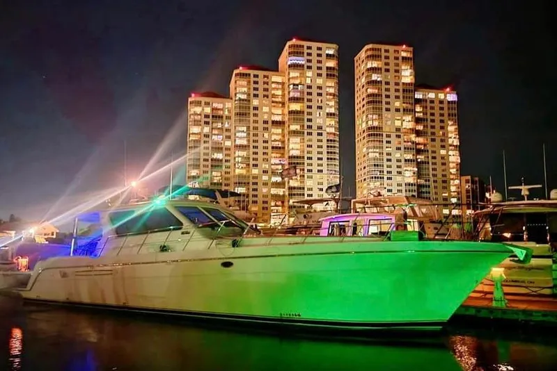 The Image of Luxury yacht Navigator Californian Veneti 2003 docked at night with illuminated cityscape backdrop. - 0