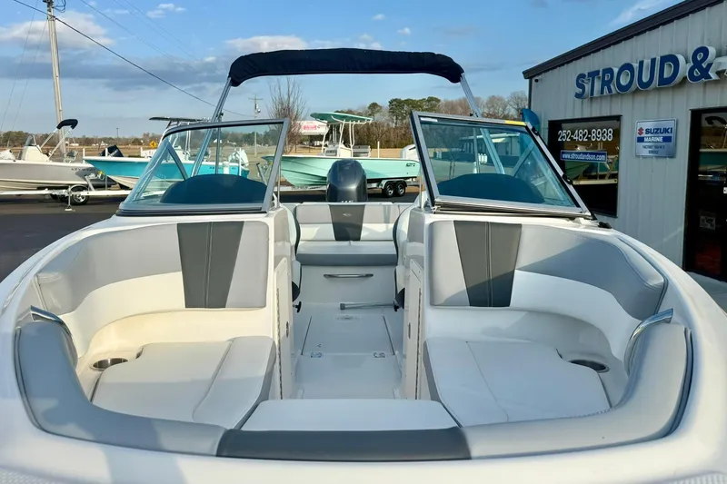 Slide: The Image of 2024 Chaparral 19 SSi OB boat with open bow seating, displayed at a dealership. - 11