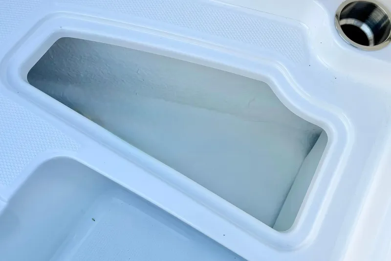 Slide: The Image of 2024 Chaparral 19 SSi OB boat detail, featuring a white compartment and stainless steel fitting. - 16