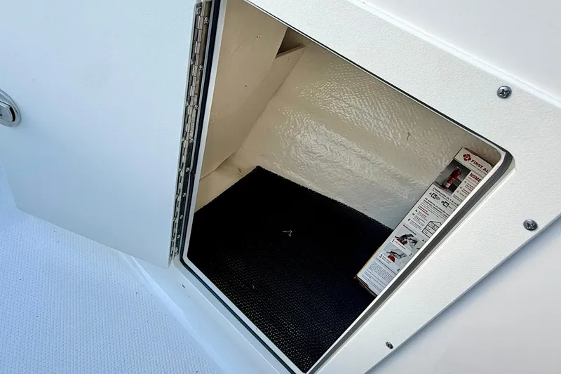 Slide: The Image of Storage compartment in 2024 Chaparral 19 SSi OB boat, featuring a first aid kit. - 26
