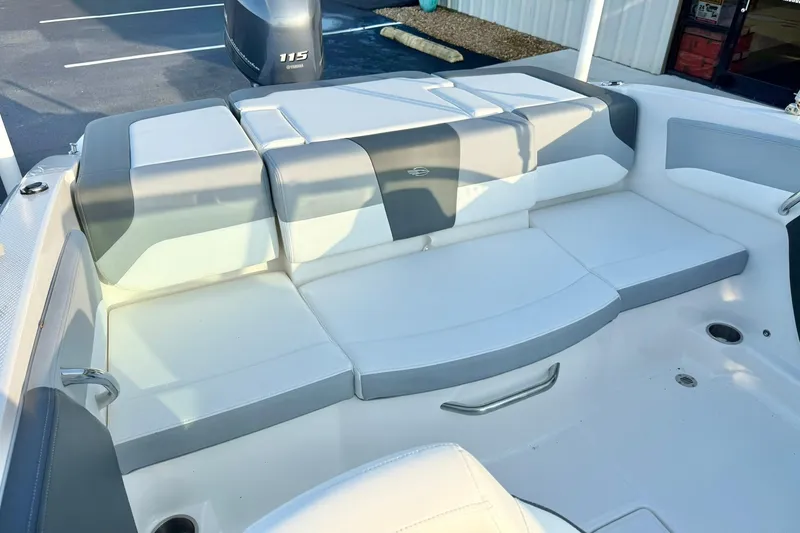 Slide: The Image of 2024 Chaparral 19 SSi OB boat interior with cushioned seating and Yamaha 115 outboard motor. - 36