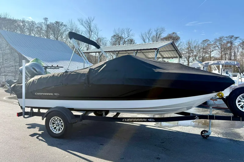 Slide: The Image of 2024 Chaparral 19 SSi OB boat covered on trailer, parked outdoors. - 4