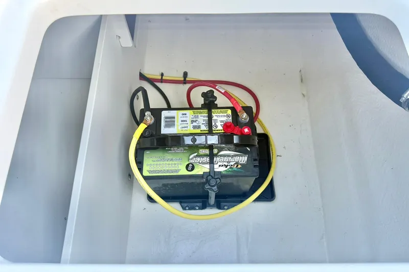 Slide: The Image of 2024 Chaparral 19 SSi OB boat battery compartment with connected cables. - 42