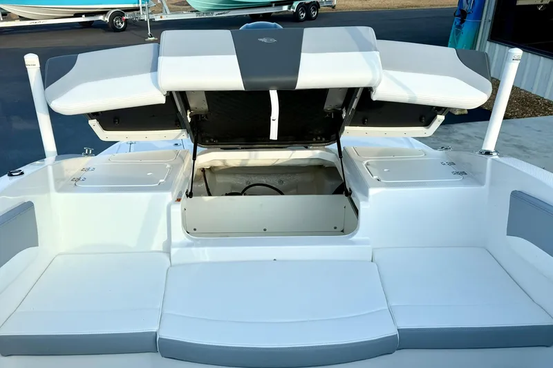 Slide: The Image of 2024 Chaparral 19 SSi OB boat with open storage compartments and cushioned seating. - 43