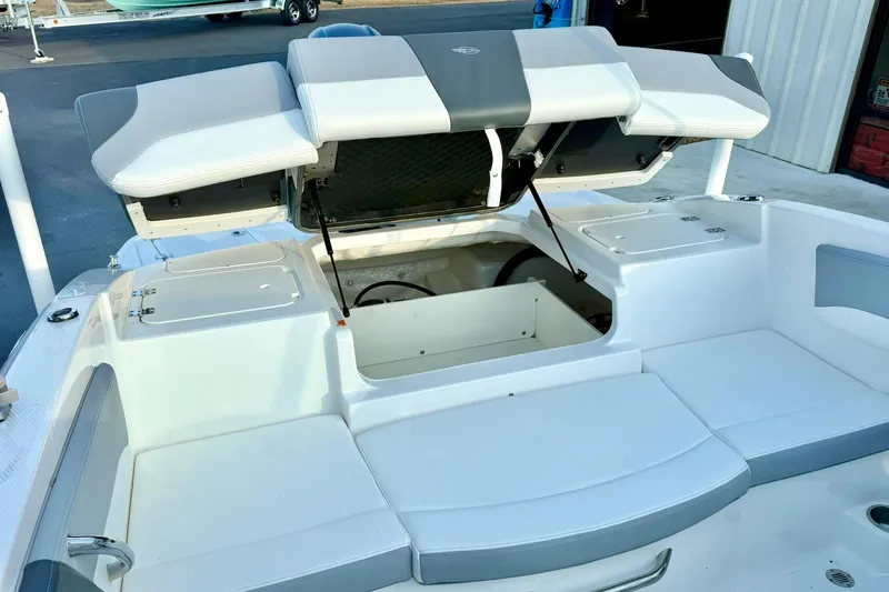 Slide: The Image of 2024 Chaparral 19 SSi OB boat with open storage compartments and cushioned seating. - 46