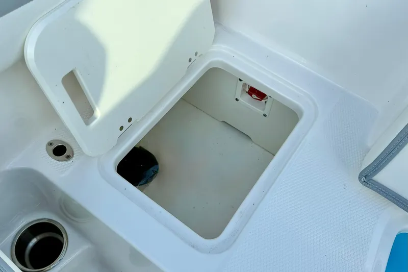 Slide: The Image of 2024 Chaparral 19 SSi OB boat storage compartment with open hatch and cup holder. - 51