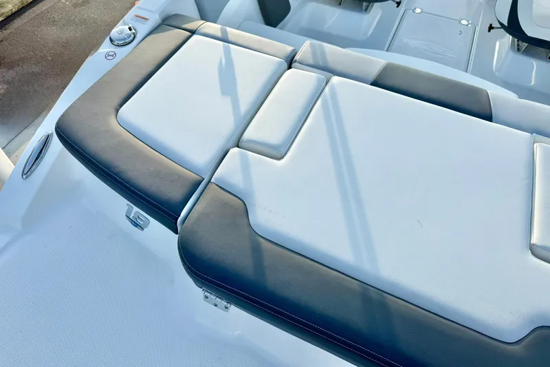 Slide: The Image of 2024 Chaparral 19 SSi OB boat interior seating, featuring sleek white and black upholstery. - 60