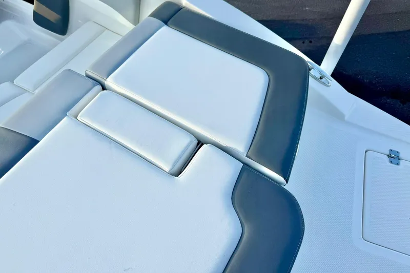 Slide: The Image of 2024 Chaparral 19 SSi OB boat interior seating, featuring sleek white and gray upholstery. - 61