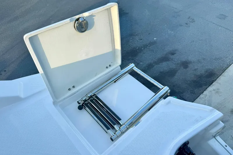 Slide: The Image of 2024 Chaparral 19 SSi OB boat ladder compartment, open with stainless steel ladder. - 63