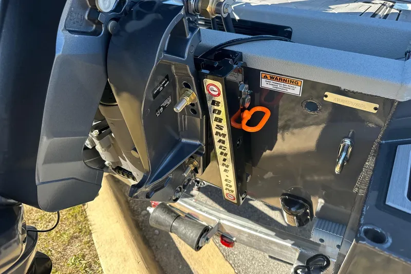 Slide: The Image of 2026 Avid 18 Commander boat engine mount with warning label and hardware. - 9