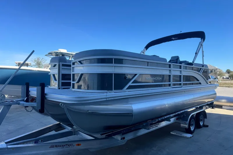 Slide: The Image of 2026 Bennington 23 SSR pontoon boat on trailer under clear blue sky. - 3