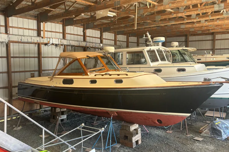 Slide: The Image of 2005 C.W. Hood Katama 30 boat in storage, featuring classic design and wooden accents. - 13