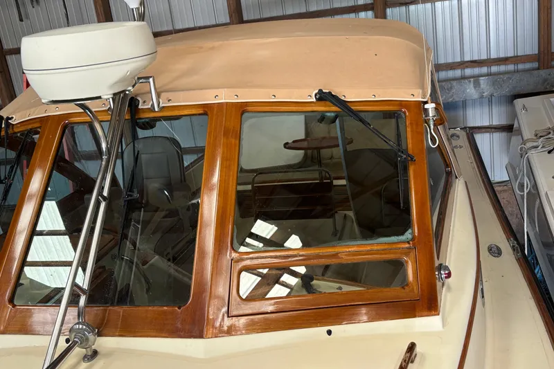 Slide: The Image of 2005 C.W. Hood Katama 30 boat with wooden trim and beige canopy in storage. - 19
