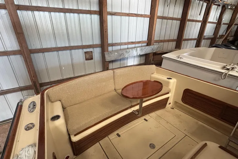 Slide: The Image of 2005 C.W. Hood Katama 30 boat interior with cushioned seating and wooden table. - 9