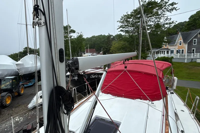 Slide: The Image of 2017 Jeanneau Sun Odyssey 389 sailboat with red canopy, docked near houses and trees. - 26