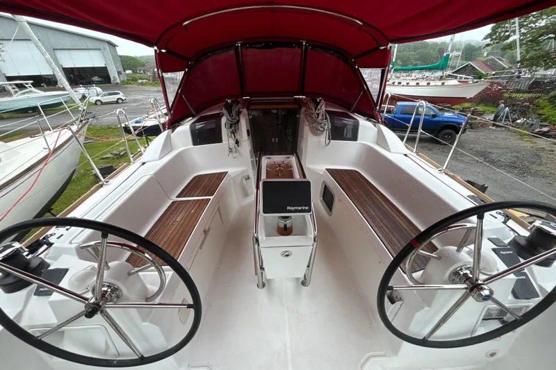 Slide: The Image of 2017 Jeanneau Sun Odyssey 389 sailboat cockpit with dual steering wheels and red canopy. - 28