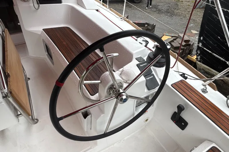 Slide: The Image of Steering wheel of 2017 Jeanneau Sun Odyssey 389 sailboat, featuring teak accents and navigation controls. - 30