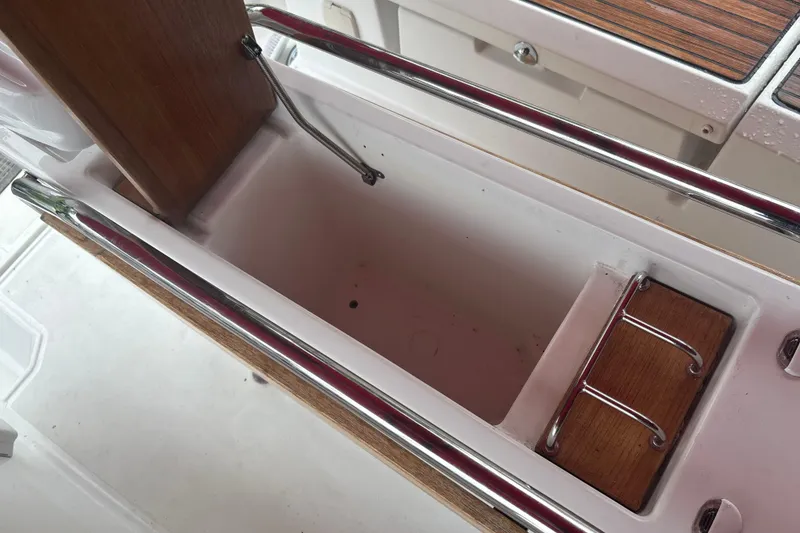 Slide: The Image of Storage compartment on 2017 Jeanneau Sun Odyssey 389 sailboat, featuring wood and metal details. - 33