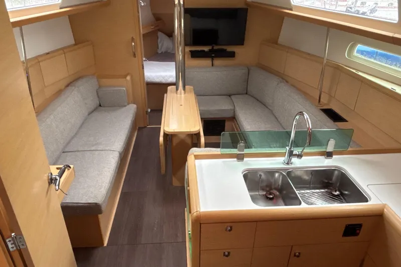 Slide: The Image of Interior of 2017 Jeanneau Sun Odyssey 389 yacht with modern kitchen and cozy seating area. - 34