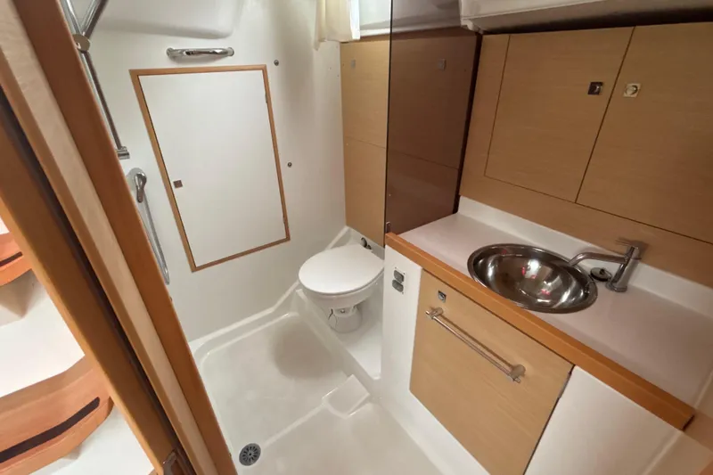Slide: The Image of 2017 Jeanneau Sun Odyssey 389 bathroom with modern fixtures and wooden cabinetry. - 52