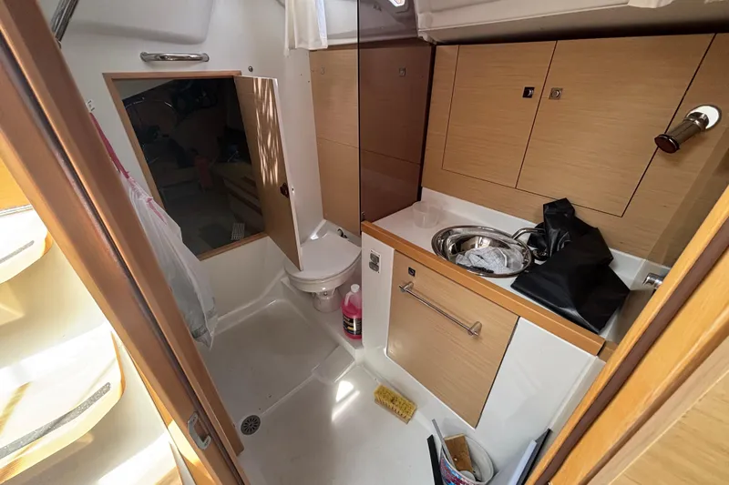 Slide: The Image of 2017 Jeanneau Sun Odyssey 389 yacht bathroom with sink, toilet, and storage cabinets. - 54