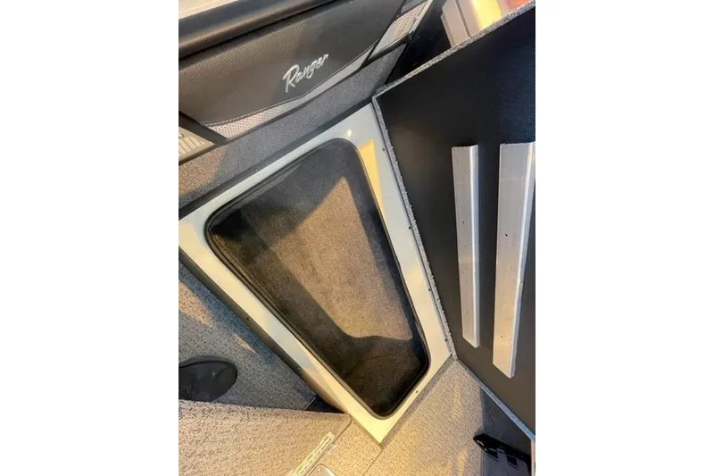 Slide: The Image of 2024 Ranger VX1988 WT interior storage compartment with carpeted lining and removable panels. - 122