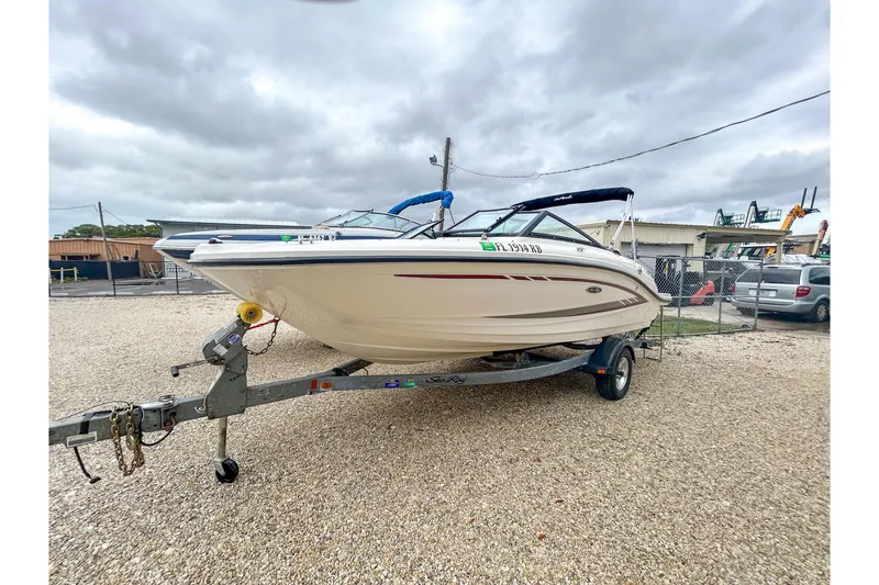 Slide: The Image of 2016 Searay 190 SPX boat on trailer in outdoor lot, cloudy sky background. - 1