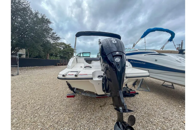 Slide: The Image of 2016 Searay 190 SPX boat with outboard motor, parked on gravel lot. - 4