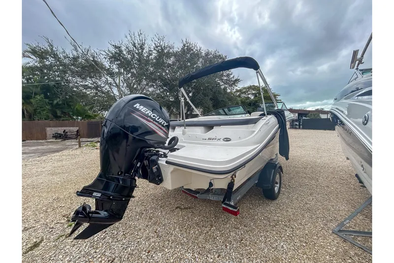 Slide: The Image of 2016 Searay 190 SPX boat with Mercury outboard engine on a gravel lot. - 5