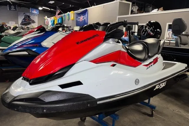 Slide: The Image of 2021 Kawasaki Jetski STX 160 in showroom, red and white design, side view. - 1