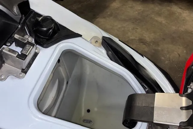 Slide: The Image of 2021 Kawasaki Jetski STX 160 storage compartment, open and empty, on a concrete floor. - 12