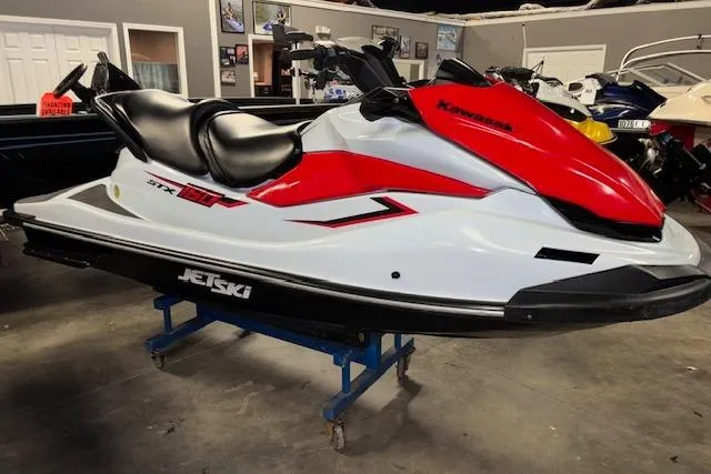Slide: The Image of 2021 Kawasaki Jetski STX 160 in showroom, red and white design. - 2