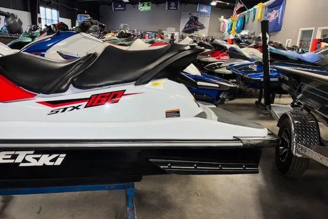 Slide: The Image of 2021 Kawasaki Jetski STX 160 in showroom, side view with trailer attachment. - 6