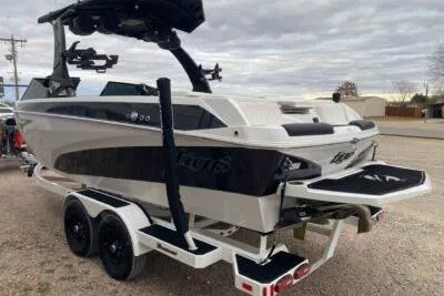 Slide: The Image of 2023 Tigé Z3 boat on trailer, sleek design, dual axle, overcast sky. - 3