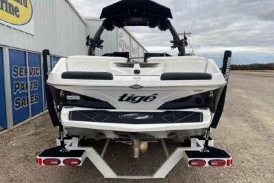 Slide: The Image of 2023 Tigé Z3 boat rear view, parked near service and parts building. - 4